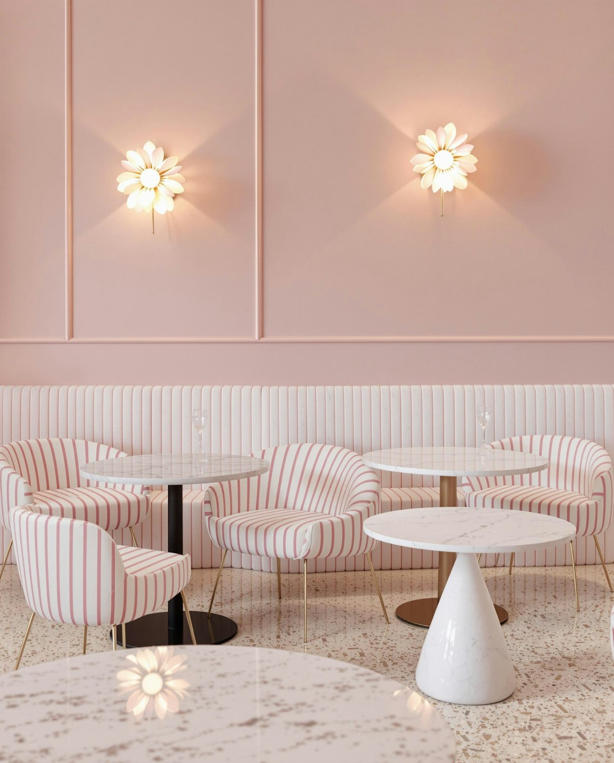A pastel pink café interior with striped armchairs, marble tables and glowing flower-shaped wall lights